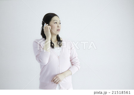 自然光白バック40代女性ミドルエイジ　スマホ／携帯電話いろんなシチュエーションの対応とジェスチャー 21518561