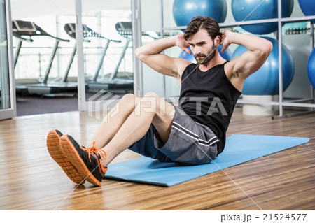Serious man doing abdominal on the mat 21524577