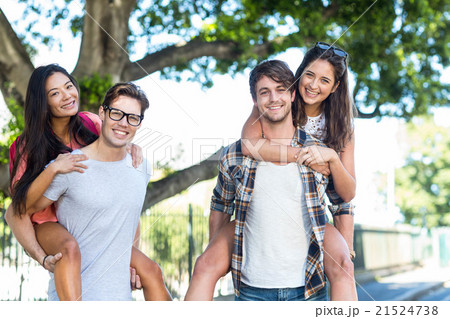 Hip men giving piggy back to their girlfriends Hip men giving piggy back to their girlfriends 21524738