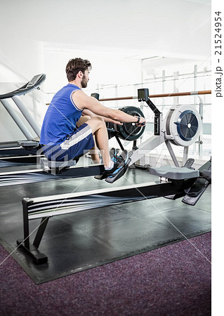 Handsome man doing exercise on drawing machine Handsome man doing exercise on drawing machine 21524954