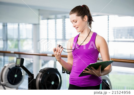 Smiling trainer looking at stopwatch Smiling trainer looking at stopwatch 21524956