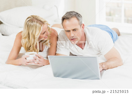 Cute couple using laptop in bed Cute couple using laptop in bed 21525015