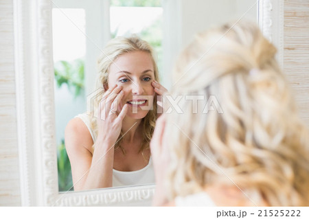 Beautiful woman looking at herself in the mirror 21525222