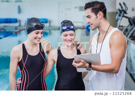 Trainer talking with smiling swimmers Trainer talking with smiling swimmers 21525268