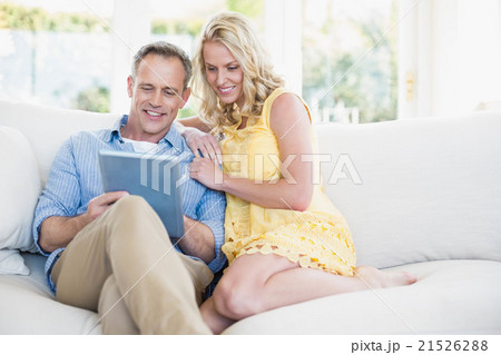 Happy couple using tablet on the sofa 21526288
