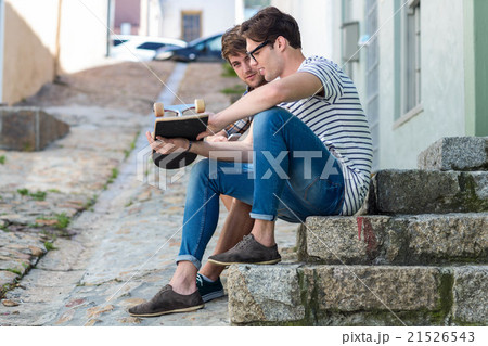 Hip men sitting on steps and holding skateboard 21526543