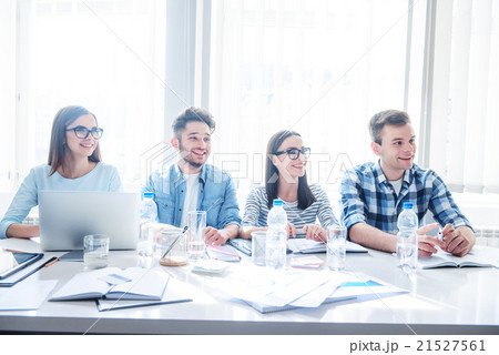 Cheerful colleagues sitting at the table  21527561