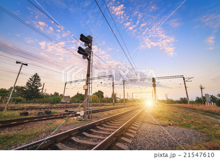 Train platform and traffic light at sunset. 21547610