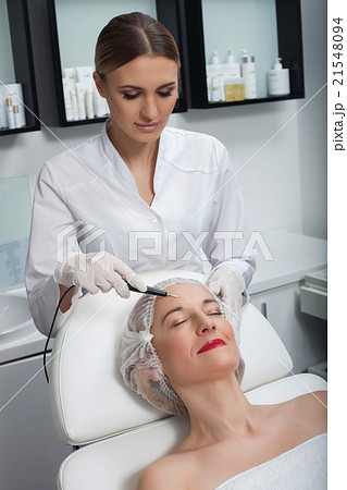 Skillful young cosmetologist is serving her 21548094