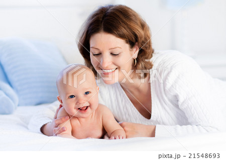 Mother and baby on a white bed 21548693