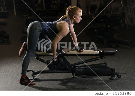 Young woman lifting the dumbbells Young woman lifting the dumbbells 21553390