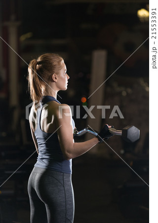 Young woman lifting the dumbbells 21553391