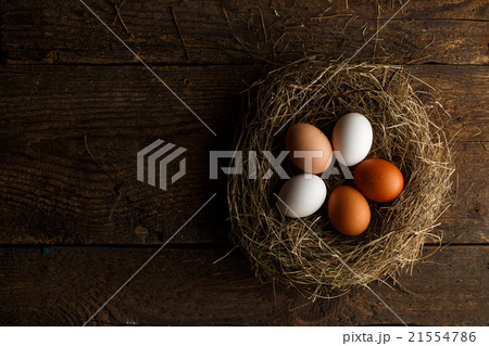 Chicken eggs in a nest on a wooden rustic background Chicken eggs in a nest on a wooden rustic background 21554786
