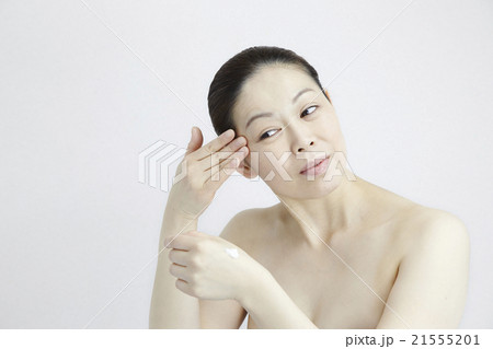 美容と健康、スキンケアお手入れシーン、目元の小じわ、40代中年女性、自然光白バック 21555201