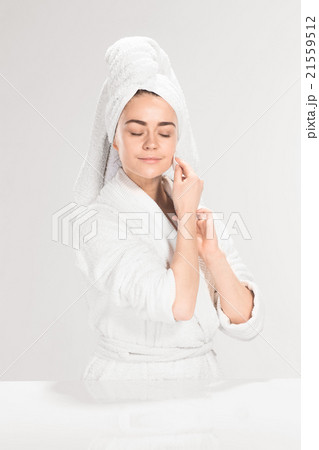 Woman cleaning face in bathroom Woman cleaning face in bathroom 21559512