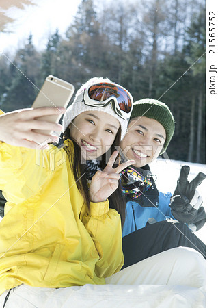 スキー場で写真を撮るカップル 21565752