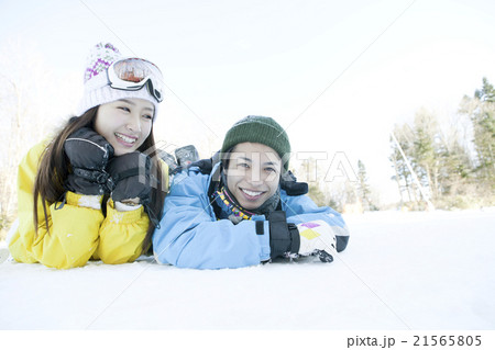 雪の上に寝転ぶ20代カップル 雪の上に寝転ぶ20代カップル 21565805