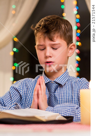 Boy praying at the table. Boy praying at the table. 21571544