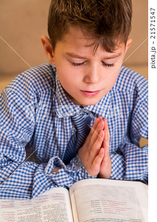 Boy praying with eyes closed. 21571547