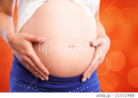 Composite image of pregnant woman holding her bump 21572488