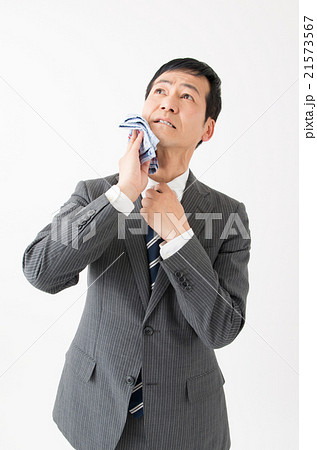 ハンカチで汗を拭くビジネスマンの写真素材