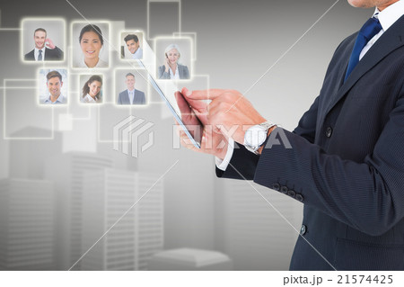 Composite image of businessman in suit using digital tablet 21574425
