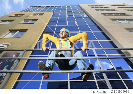 .a young man in overalls on background glassed building .a young man in overalls on background glassed building 21580945