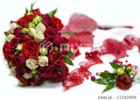 A wedding bouquet with red roses and a red tape A wedding bouquet with red roses and a red tape 21582808