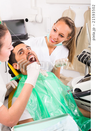 Dentist examines patient at clinic. 21593502