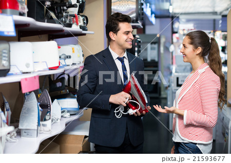 Choosing clothes iron in hypermarket . Choosing clothes iron in hypermarket . 21593677