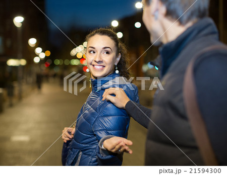 man flirting with smiling brunette woman in late evening 21594300