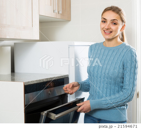 Girl near kitchen oven at home. 21594671