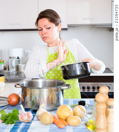 Woman with smelly pan in kitchen Woman with smelly pan in kitchen 21594735