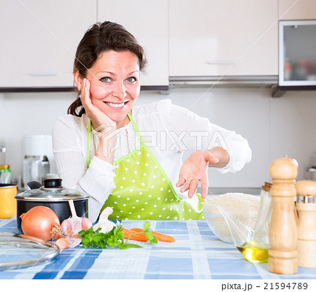 Woman in apron sitting at table 21594789