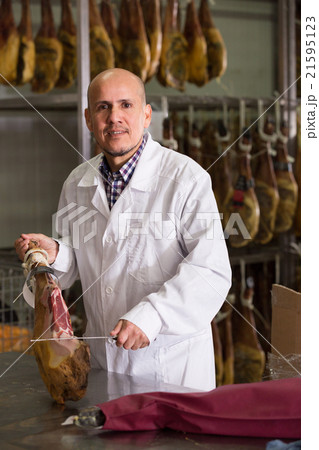 Salesman cutting jamon on slices 21595123