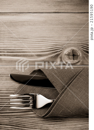 knife and fork at napkin on wood 21595190