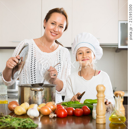 Smiling girl and mom at kitchen 21595300