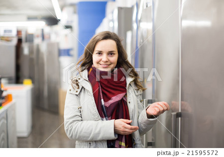 brunette choosing new refrigerator in hypermarket brunette choosing new refrigerator in hypermarket 21595572