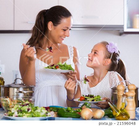 Mother and daughter eating salad 21596048