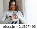 Youngsmiling woman chatting to her friends on the 21597493