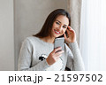Youngsmiling woman chatting to her friends on the 21597502