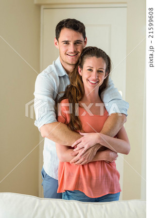 Young couple embracing in living room Young couple embracing in living room 21599608