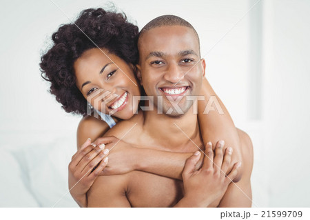 Happy couple embracing on bed Happy couple embracing on bed 21599709