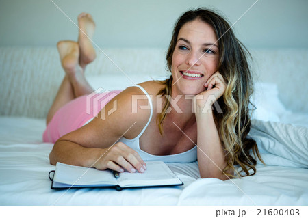 smiling woman reading n a book 21600403
