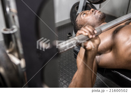 Shirtless man lifting barbell on bench 21600502