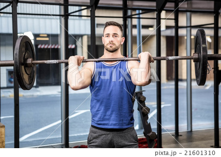 Muscular man lifting barbell on bench 21601310