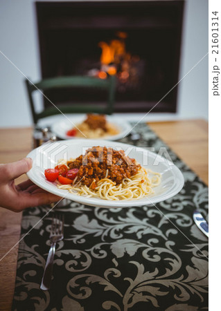 Person putting spaghetti on table 21601314