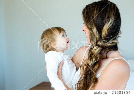 smiling brunette woman holding a happy baby smiling brunette woman holding a happy baby 21601354