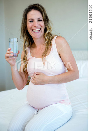 smiling pregnant woman drinking water smiling pregnant woman drinking water 21601510