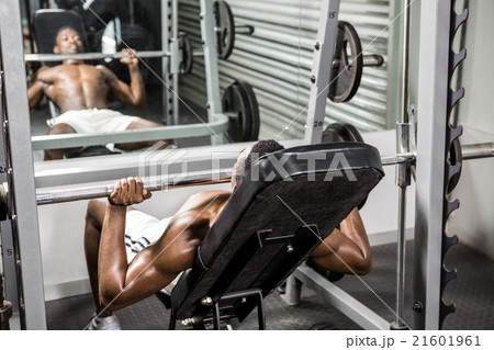 Shirtless man lifting barbell on bench Shirtless man lifting barbell on bench 21601961